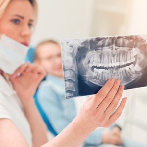 Dentist holding up patient’s X-rays to show them
