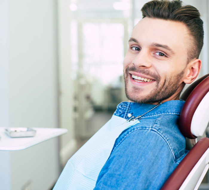 Patient smiling while sitting in treatment chair