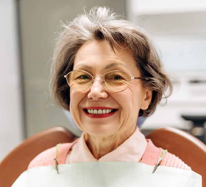 smiling older woman at the dentist office