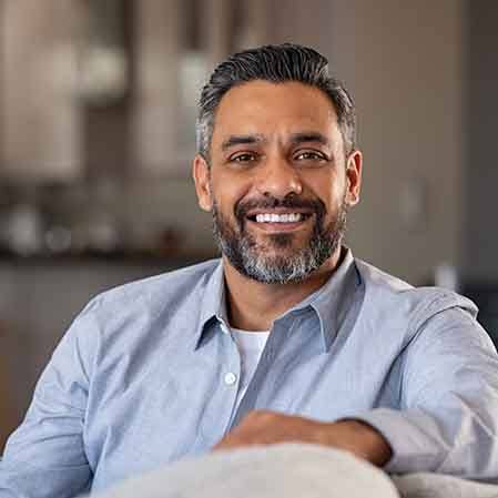 smiling middle-aged man sitting comfortably on the couch