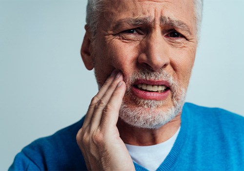 Patient in Medina Valley holding cheek