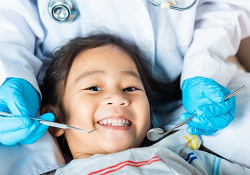 Little girl smiling about to undergo dental exam