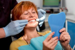 Senior woman smiling in dentist's chair.