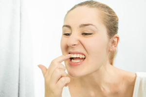 Woman checking a piece of food stuck between her teeth